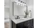 Bathroom featuring a large mirror, double sinks, white countertop, and views to the hallway at 6124 Kings Mountain Ct, Stone Mountain, GA 30087