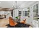 Sunlit dining area with bay window, chandelier, and glass table, adjacent to living room at 6124 Kings Mountain Ct, Stone Mountain, GA 30087
