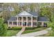 Stately brick home with white columns, black shutters, and mature landscaping provides classic curb appeal at 6124 Kings Mountain Ct, Stone Mountain, GA 30087