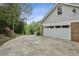 Attached two-car garage with a concrete driveway, showcasing ample parking and convenient access to the home at 6124 Kings Mountain Ct, Stone Mountain, GA 30087