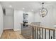 Upstairs hallway with hardwood floors and decorative lighting at 6124 Kings Mountain Ct, Stone Mountain, GA 30087