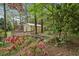 Landscaped backyard featuring an outbuilding with a small deck, adding character and functionality to the property at 6124 Kings Mountain Ct, Stone Mountain, GA 30087