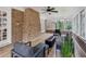 Bright sunroom with brick accent wall, neutral decor, ceiling fan, and several windows offering ample light at 6124 Kings Mountain Ct, Stone Mountain, GA 30087