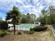 Community pool surrounded by lush landscaping and a white picket fence for safety and beauty at 10900 Wittenridge Dr # D5, Alpharetta, GA 30022