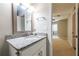 Bathroom featuring granite vanity, decorative mirror, and doorway leading to a carpeted room at 1207 Mcclelen Way, Decatur, GA 30033