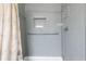 Bathroom featuring gray tile shower with grab bar, and white tub with light-patterned shower curtain at 1207 Mcclelen Way, Decatur, GA 30033