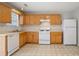 Efficient kitchen layout with wooden cabinets, neutral countertops, and essential appliances for easy meal preparation and cooking at 3116 Fields Dr, Lithonia, GA 30038