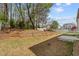 A spacious backyard with a fire pit, terraced garden beds, and a classic white picket fence at 3806 Carriage House Dr, Cumming, GA 30040