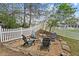 Cozy backyard fire pit with Adirondack chairs, perfect for outdoor entertaining by the white fence at 3806 Carriage House Dr, Cumming, GA 30040