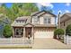 Charming two-story home with stone accents, attached two car garage and white picket fence at 3806 Carriage House Dr, Cumming, GA 30040