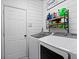 A well-organized laundry room featuring a washer, dryer, storage shelves, and fresh, white walls at 3806 Carriage House Dr, Cumming, GA 30040
