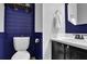 Powder room with navy accent wall, white walls and cabinet, and wood-look floors at 925 Crab Orchard Dr, Roswell, GA 30076