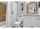 Bathroom with tan tile shower, white vanity, and arched mirror at 925 Crab Orchard Dr, Roswell, GA 30076