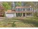 Charming two-story home with a welcoming front porch and well-maintained lawn in a wooded setting at 925 Crab Orchard Dr, Roswell, GA 30076