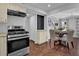 Open kitchen with stainless steel gas range, and hardwood floors at 925 Crab Orchard Dr, Roswell, GA 30076