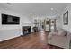 Spacious living room with hardwood floors, fireplace, and ample natural light from large windows at 925 Crab Orchard Dr, Roswell, GA 30076