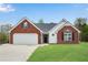 Charming single-story brick and white home featuring a well-manicured lawn and two-car garage at 111 Shenandoah Ct, Hiram, GA 30141