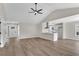 Open-concept living room boasts wood floors, ceiling fan, and view into the kitchen at 111 Shenandoah Ct, Hiram, GA 30141