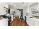 Beautiful kitchen adjacent to the living room and features stainless appliances, white cabinets, and hardwood floors at 645 Trailmore Pl, Roswell, GA 30076