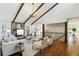 Open-concept living room with a stone fireplace, hardwood floors, and exposed beam vaulted ceiling at 645 Trailmore Pl, Roswell, GA 30076