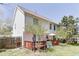 A home's backyard with a wooden fence, a wooden deck with table and umbrella, and foliage at 1480 Bramlett Forest Se Trl, Lawrenceville, GA 30045
