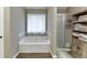 Bright bathroom with a bathtub, shower, wood look floor, and plenty of storage at 1480 Bramlett Forest Se Trl, Lawrenceville, GA 30045