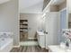 Well-lit bathroom with a bathtub, shower, modern finishes, and great storage at 1480 Bramlett Forest Se Trl, Lawrenceville, GA 30045