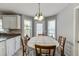 Eat-in kitchen area with tile floors and table next to a window and white cabinetry at 1480 Bramlett Forest Se Trl, Lawrenceville, GA 30045