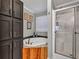 Bathroom featuring a corner tub with wood paneling, a glass-enclosed shower, and gray cabinets at 2466 Monroe Jersey Rd, Covington, GA 30014