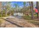 Cozy home nestled in a wooded area with American flag, storage building, and gravel drive at 2466 Monroe Jersey Rd, Covington, GA 30014