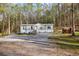 Single-story home with white trim, nestled in a wooded area with long gravel driveway at 2466 Monroe Jersey Rd, Covington, GA 30014