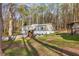 Cozy home nestled among tall trees on a verdant lawn with a partial view of the drive at 2466 Monroe Jersey Rd, Covington, GA 30014