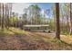 Exterior of a home surrounded by mature trees and greenery with a gravel driveway at 2466 Monroe Jersey Rd, Covington, GA 30014