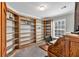 Office featuring wood bookshelves, a built-in desk, a computer and a dark swivel chair at 2466 Monroe Jersey Rd, Covington, GA 30014