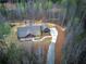 Stunning aerial view of home with long driveway, wooded acreage, and immaculate landscaping at 313 Morgan Rd, Temple, GA 30179