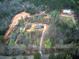 A high angle aerial view showing two homes with driveway amongst surrounding forest at 313 Morgan Rd, Temple, GA 30179