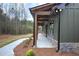 Home exterior featuring a covered porch with wood columns, stone accents, and well-maintained landscaping at 313 Morgan Rd, Temple, GA 30179