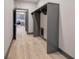 Hallway featuring hardwood floors, gray trim, and an open shelf closet with a view of the kitchen at 313 Morgan Rd, Temple, GA 30179