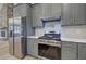 Gray cabinetry, stainless steel appliances, and tiled backsplash at 313 Morgan Rd, Temple, GA 30179