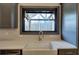 Close-up of a farmhouse style kitchen sink with goose neck faucet and an awning window at 313 Morgan Rd, Temple, GA 30179
