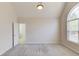 Bright bedroom with plush carpeting, a vaulted ceiling, and a view of the outdoors at 4155 Cami Way, Buford, GA 30519