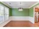 Stylish dining room with wainscoting, modern lighting, and hardwood floors adjacent to kitchen at 4155 Cami Way, Buford, GA 30519