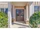 Elegant entryway showcasing double doors, trimmed with decorative pillars, and accented by lush greenery at 4155 Cami Way, Buford, GA 30519