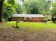 Expansive backyard with ample green space, patio area, and serene, wooded surroundings at 3727 Dial Dr, Stone Mountain, GA 30083