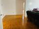 Open living room featuring hardwood floors, white walls, and comfortable seating near a hallway at 3727 Dial Dr, Stone Mountain, GA 30083