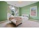 Green painted bedroom featuring a bed and couch near windows with natural light and a geometric design accent wall at 4402 Income Cir, Ellenwood, GA 30294