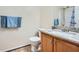 Bathroom featuring a single sink, granite countertops, wood cabinets, and well-maintained tile flooring at 5997 Tate Dr, Austell, GA 30106