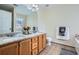 Bathroom featuring dual sinks, granite countertops, wood cabinets, and well-maintained tile flooring at 5997 Tate Dr, Austell, GA 30106