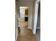 View of hallway with brown tile leading to the kitchen at 709 Kilkenny Cir, Lithonia, GA 30058