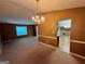 Open living and dining area with chandelier lighting and neutral tones, ideal for entertaining and relaxation at 709 Kilkenny Cir, Lithonia, GA 30058
